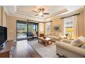 Bright living room with hardwood floors, comfy sofas, and pool view at 13202 Torresina Ter, Bradenton, FL 34211