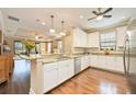 Modern kitchen with white cabinets, granite counters, and hardwood floors at 13202 Torresina Ter, Bradenton, FL 34211