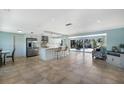 Open floor plan with a spacious living room, tile floors, kitchen island, and sliders to the pool at 506 69Th St, Holmes Beach, FL 34217