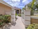 Inviting entryway with a white metal gate and landscaping at 424 Cardiff Rd # 27, Venice, FL 34293