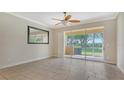 Living room with tile floors, ceiling fan, and sliding doors at 11415 52Nd E Ct, Parrish, FL 34219
