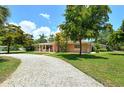 House with a gravel driveway and mature trees in the front yard at 3225 Duncan Way, Sarasota, FL 34239