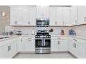 Modern kitchen with white cabinets, stainless steel appliances, and white backsplash at 10136 Milky Way Cir, Sarasota, FL 34241