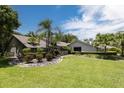 House exterior showcasing a large lawn and mature trees at 4714 Elder Berry Dr, Sarasota, FL 34241