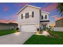 Two-story house with gray siding, white garage door, and landscaping at 335 Gris Sky Ln, Bradenton, FL 34212