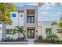 Contemporary home featuring a stucco facade, double-door entry, balcony and meticulous landscaping at 2430 Floyd St, Sarasota, FL 34239