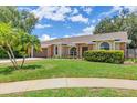 Attractive single-story home with a well-kept lawn, lush landscaping, and mature palm trees, enhancing curb appeal at 4709 Foy Pl, Sarasota, FL 34243