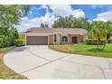 Beautifully landscaped home with a spacious driveway, attached two-car garage, and well-manicured lawn at 4709 Foy Pl, Sarasota, FL 34243