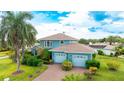 Charming two-story home with a well-manicured lawn, beautiful landscaping, and a brick driveway leading to a two-car garage at 8607 51St W Ave, Bradenton, FL 34210