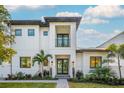Stunning two-story home features a clean white facade, balcony, and lush landscaping at 2440 Floyd St, Sarasota, FL 34239