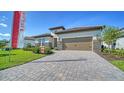 Attractive home exterior featuring a brick driveway, manicured lawn, and stone accents at 429 Alberata Way, Nokomis, FL 34275
