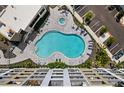 Aerial view of the kidney-shaped swimming pool and surrounding lounge area at 1703 N Tamiami Trl # 302, Sarasota, FL 34234