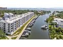 Waterfront condo building with boat docks and lush landscaping at 1703 N Tamiami Trl # 302, Sarasota, FL 34234