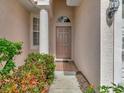 Inviting front entrance with a column accent, brick tile landing, and decorative door at 4145 Reflections Pkwy, Sarasota, FL 34233