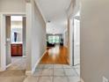 Bright hallway with tile flooring, leading to a spacious living area with hardwood floors at 4145 Reflections Pkwy, Sarasota, FL 34233