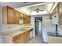 View of kitchen with wood cabinets, white appliances, and a double sink at 505 30Th W Ave # E304, Bradenton, FL 34205