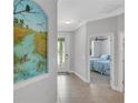 Bright entryway with a nature-themed mural and view of bedroom at 18050 Wooden Skiff Ct, Nokomis, FL 34275