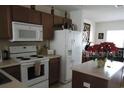 Kitchen features include white appliances and an island at 7365 Black Walnut Way, Lakewood Ranch, FL 34202
