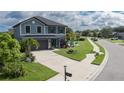 Two-story home with a gray roof and a blue facade, an attached garage, and inviting landscaping at 8825 52Nd E Ave, Palmetto, FL 34221