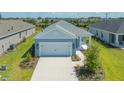 Single-story home with light blue exterior, two-car garage, and landscaped yard at 14551 Skipping Stone Loop, Parrish, FL 34219