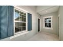 Front entrance with teal shutters and light walls at 14705 Barefoot Ln, Parrish, FL 34219