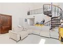 Spacious living room with a large sectional sofa and a spiral staircase at 6515 Mauna Loa Blvd, Sarasota, FL 34241