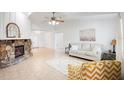 Bright living room featuring a stone fireplace, neutral furniture, tile flooring, and lots of natural light at 4175 Arrow Ln, Sarasota, FL 34232