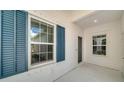 Covered entryway with blue shutters and white siding at 14631 Barefoot Ln, Parrish, FL 34219