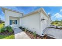 White house with blue shutters, two-car garage, and landscaping at 14631 Barefoot Ln, Parrish, FL 34219