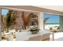 An airy dining room with white table and chairs, offers expansive ocean views at 107 Elm Ave, Anna Maria, FL 34216