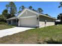 A side view of a well-maintained home featuring a two-car garage and a concrete driveway at 4012 Oscar Ter, North Port, FL 34286