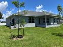 View of the home's rear exterior featuring a covered patio and freshly seeded lawn at 4860 Florida Rd, Venice, FL 34293