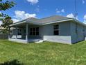 Well-maintained home featuring a covered patio, lush lawn, and a recently painted exterior at 4860 Florida Rd, Venice, FL 34293
