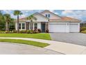 Two-story house with a three-car garage and lush landscaping at 6600 Dovekey Dr, Sarasota, FL 34241