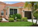 Front view of a house with a one-car garage at 5635 Spanish Point Ct, Palmetto, FL 34221