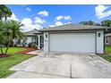 Single story home with attached garage and landscaped yard at 2484 Cover Ln, North Port, FL 34286