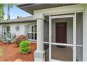 Red front door entrance with a screened porch at 2484 Cover Ln, North Port, FL 34286