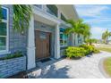 Close up of front entrance with gray brick, wood door, and landscaping at 3502 Bahia Vista St, Sarasota, FL 34239