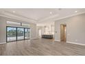 Open floor plan featuring wood-style flooring, recessed lighting, and a modern kitchen with a large island at 10629 Nicklaus Ct, Englewood, FL 34223