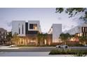 Modern townhome community with sleek design and lush landscaping, illuminated at dusk at 1611 4Th St # B6, Sarasota, FL 34236