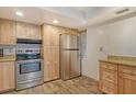 Kitchen with light wood cabinets, stainless steel appliances, and granite countertops at 1350 N Portofino Dr # 310, Sarasota, FL 34242