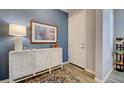 Stylish entryway with blue accent wall, white console table, decorative lamp, and front door at 8930 Tuscany Isles Dr, Punta Gorda, FL 33950