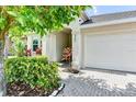 House exterior featuring a white facade, landscaped front yard, and a white garage door at 4247 Adelaar Dr, Sarasota, FL 34240