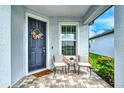 Front porch with two chairs, side table, and welcoming door decor at 10434 Spring Tide Way, Parrish, FL 34219