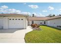 Front view of a single-story home with a two-car garage and well-maintained lawn at 3712 W 3Rd Ave, Palmetto, FL 34221