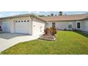 Front view of a single-story home with a two-car garage and landscaped yard at 3712 3Rd W Ave, Palmetto, FL 34221