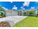 Luxury home exterior with stone accents and palm trees at 11414 Brightly Dr, Venice, FL 34293