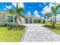 Luxury home exterior with stone accents and palm trees at 11414 Brightly Dr, Venice, FL 34293
