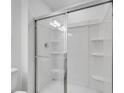 The bathroom showcases a streamlined glass-enclosed shower, featuring built-in shelving for bathroom essentials at 3063 Novara Ln, Lakewood Ranch, FL 34211