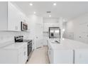 Modern kitchen with white cabinets, stainless steel appliances, and an island at 3145 Novara Ln, Lakewood Ranch, FL 34211
